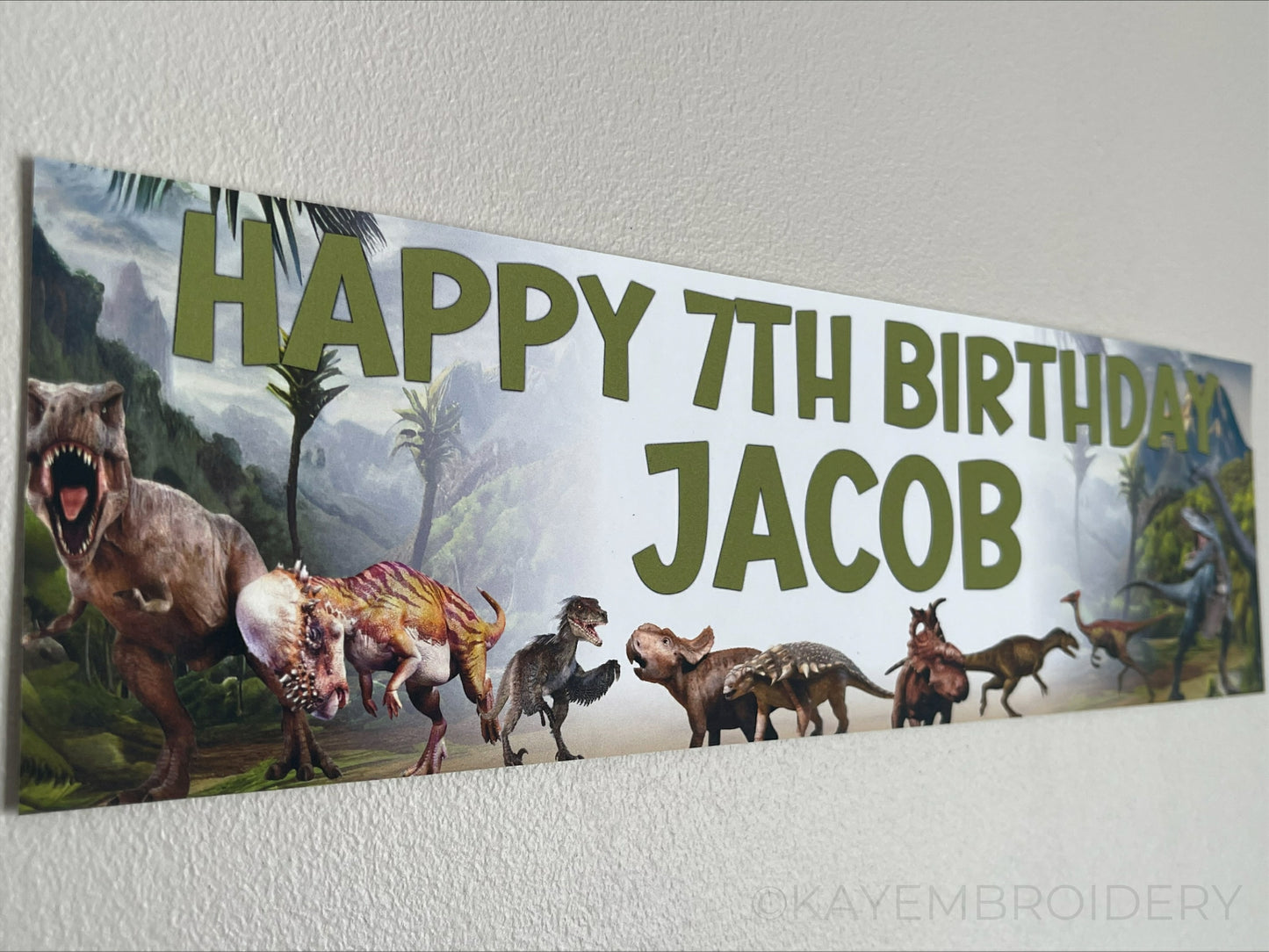 Birthday Banner with Dinosaurs set in Jurassic Background theme T rex, Triceratops, Stegosaurus, brontosaurus. Personalised with name and age in Green Text