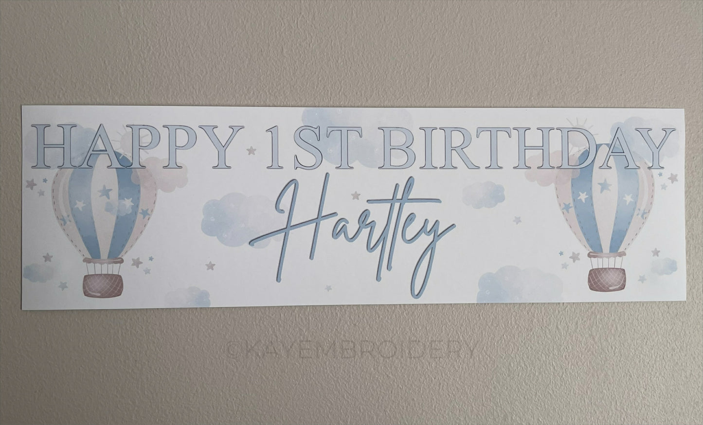 In the Sky 1st Birthday banner in blue with hot air balloons, clouds and stars, personalised with happy 1st birthday and name