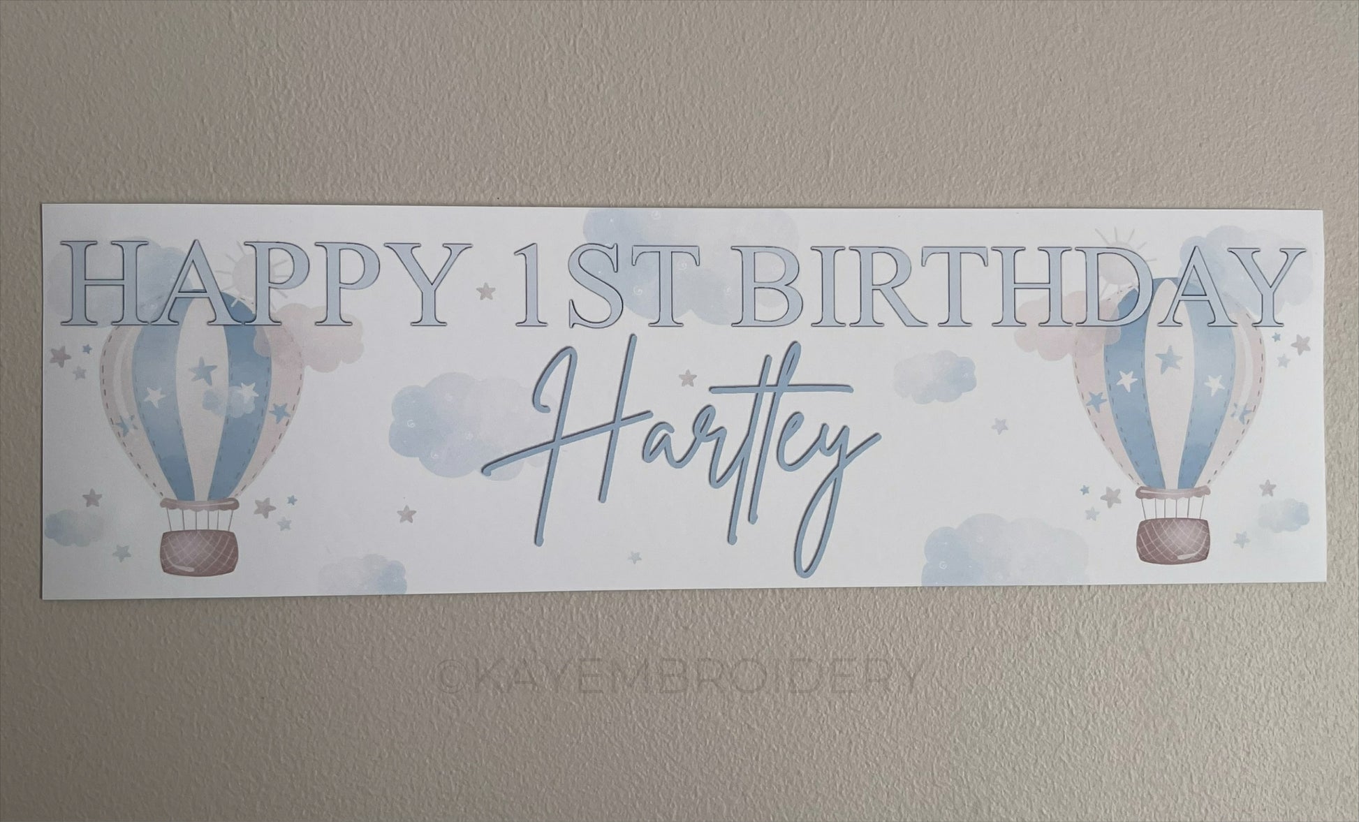 In the Sky 1st Birthday banner in blue with hot air balloons, clouds and stars, personalised with happy 1st birthday and name
