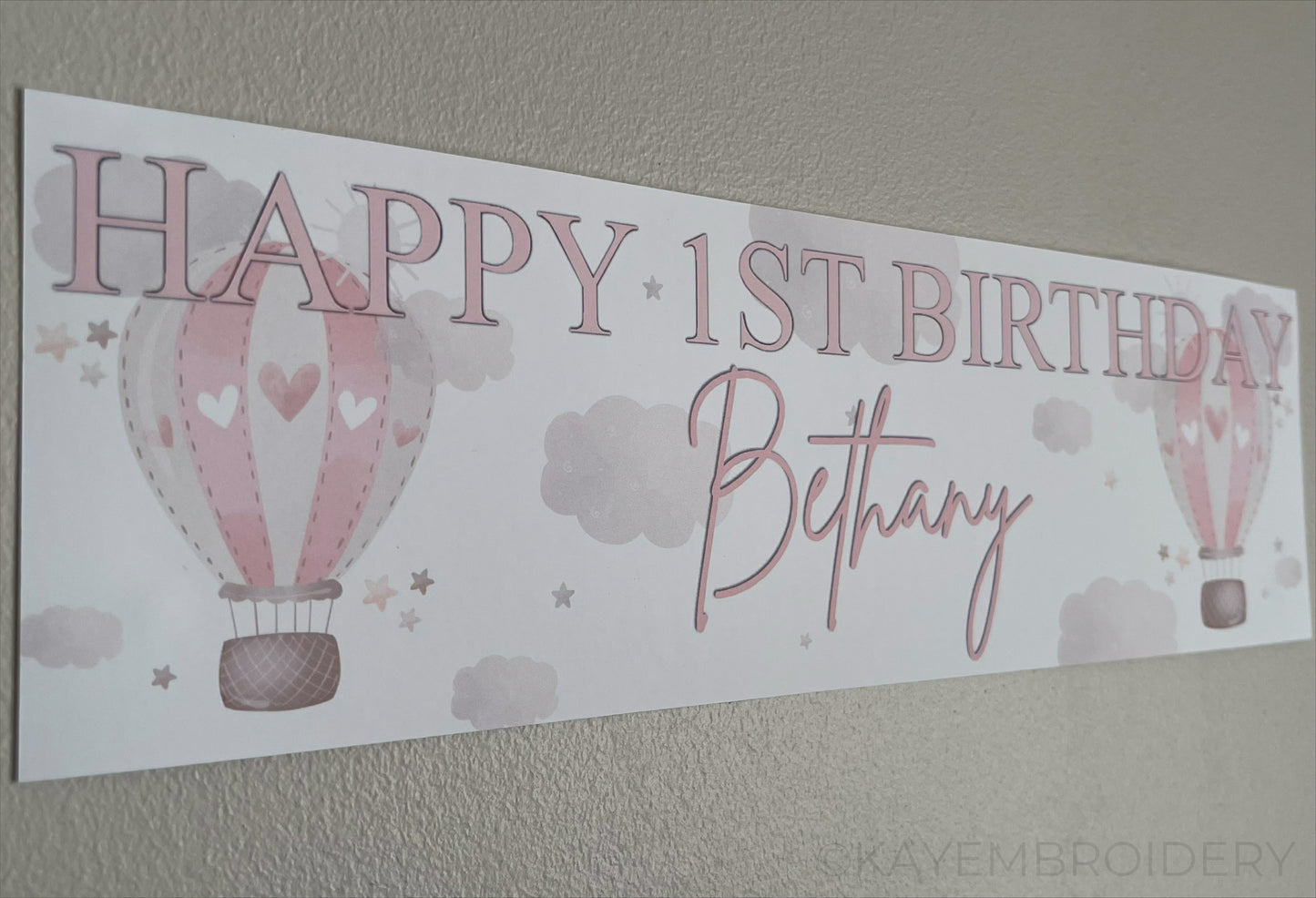 In the Sky 1st Birthday banner in pink with hot air balloons, clouds and stars, personalised with happy 1st birthday and name