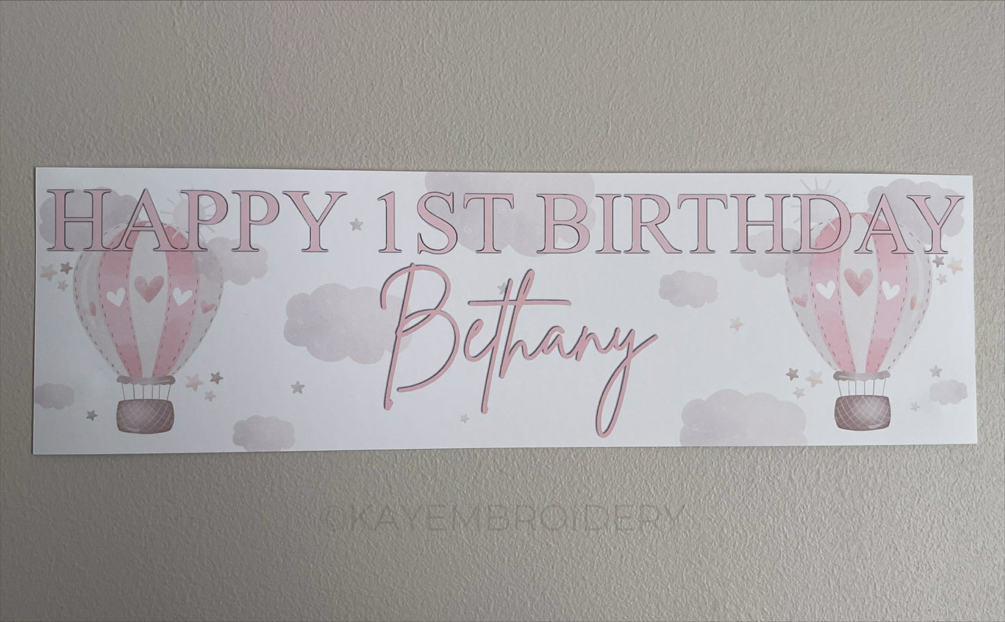 In the Sky 1st Birthday banner in pink with hot air balloons, clouds and stars, personalised with happy 1st birthday and name